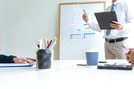 Young businessman stand in front of the group to present or business coaching to teach the technic to marketing business reach the target.の写真素材