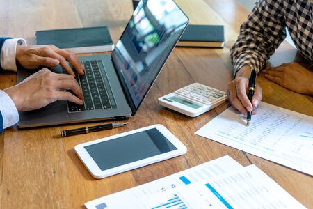 young business team in casual style have small meeting in the office talk about  analyses chart graph marketing plan with computer laptop calculator.の写真素材