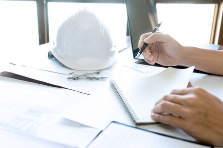 Group of engineering or architect discussing and working on blueprint with architect equipment,...