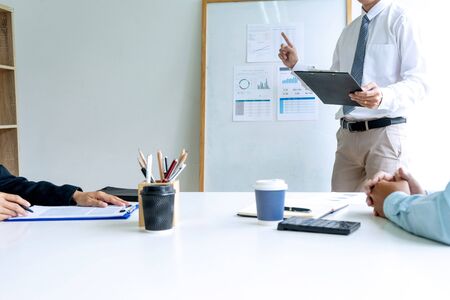 Young businessman stand in front of the group to present or business coaching to teach the technic to marketing business reach the target.の写真素材