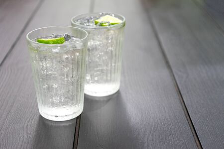 glass of cold water with lemon slide on the black wood water.の写真素材