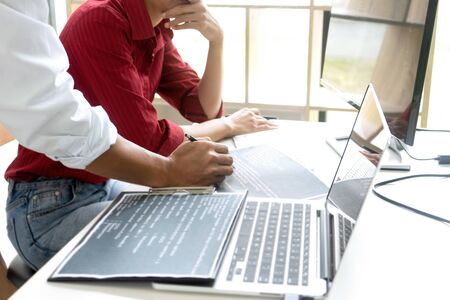 Teamwork team programmer working with computer desktop and laptop and computer code in paper print.の写真素材