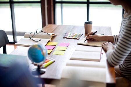 woman and man work for education or business on the table with notebook laptop and paper work color pen, in the library roomの写真素材