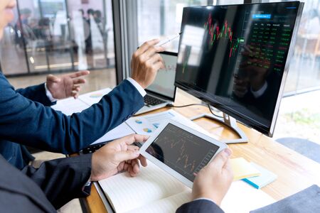 businessman sit at their table looking at computer laptop in the office, they talking about stock market invest or talk with customerの写真素材