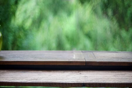 Brown Wooden board empty table texture table top on a green blur abstract background Bokeh green leafの写真素材