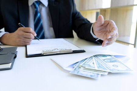 the officer or business man had bribe money with him, he take bribe for help businessman or company to sign in the new contract form. concept corruptionの写真素材