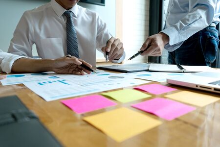 in the office Business meeting businessman and businesswoman work on the table have graph chart and color notepad  paperの写真素材