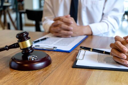 In the law firm, husband and wife signing in legal separation document, marriage law lawyer concept.の写真素材