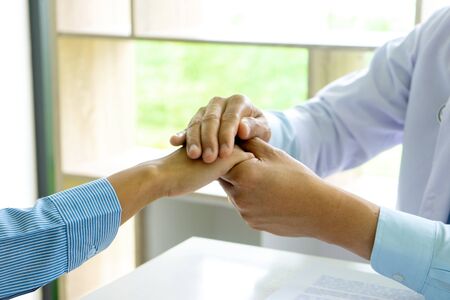 Doctor touch patient hand to give good thinking to them.の写真素材