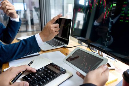 businessman sit at ther table looking at computer laptop in the office , they talking about stock market invest or talk with customerの写真素材