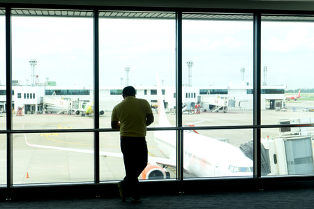 Tourist wait for airplane flight to fly to the point at the window of terminal airport.のeditorial素材