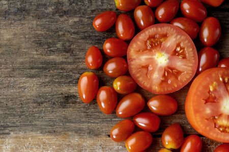 Red tomato on the old wood , group of big and small fruit.の写真素材
