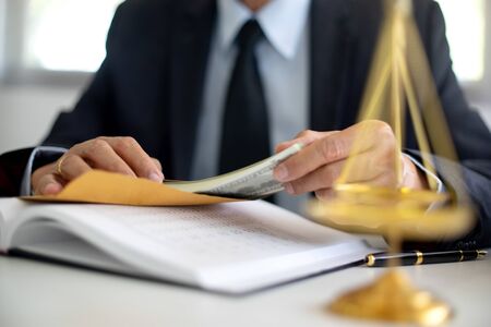 Lawyer or judge count the money on the office table, bribe corruption conceptの写真素材