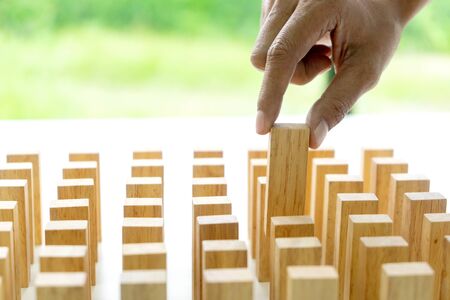 people hand choice and pick up a wood block from the group in many row.の写真素材