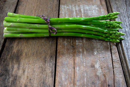 Group of Fresh asparagus on the wood background, raw vegetable food for health cook more copy space.の写真素材