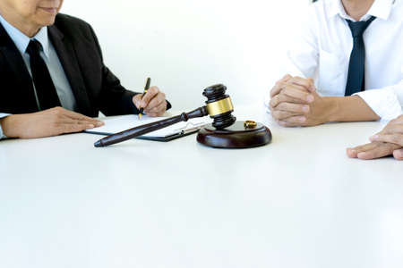 On the table in the law office business people talk about law paper, gavel and scale are on the desk.の写真素材
