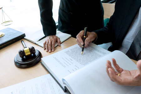 On the table in the law office business people talk about law paper, gavel and scale are on the desk.の写真素材