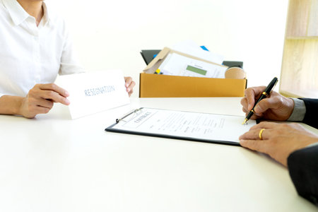 Staff worker hold the box and send resignation letter to boss or manager to tell that she quite from the job and talking about the contractの写真素材