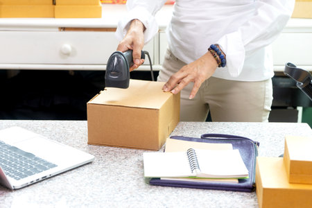 businesswomen working with box pack to prepare to deliver the product to the customer in the office there is a device for packaging products and barcode scanner.の写真素材