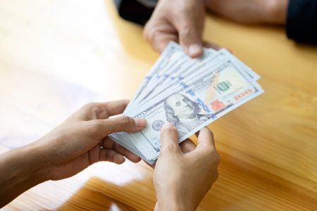Businessman or office receive cash money from another person or this banknote be salary income from their workの写真素材