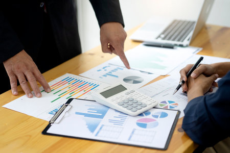 Businessman boss of the team point to graph and chart to reach the target the table for a force to the staff to work hard about the marketing target by use dataの写真素材