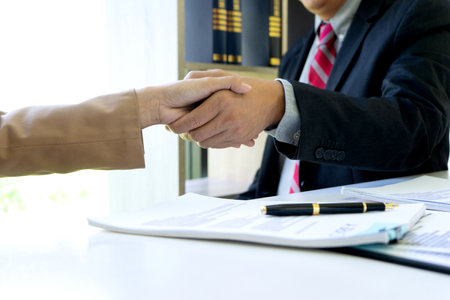 The businesswoman sit and look examined the documents the standing staff presented while working in the office.の写真素材