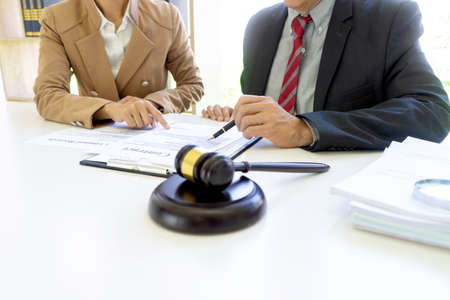 The businesswoman sit and look examined the documents the standing staff presented while working in the office.の写真素材