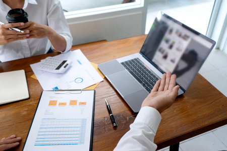 Businessmen are using his hand to present their business projects via computer screens to their...