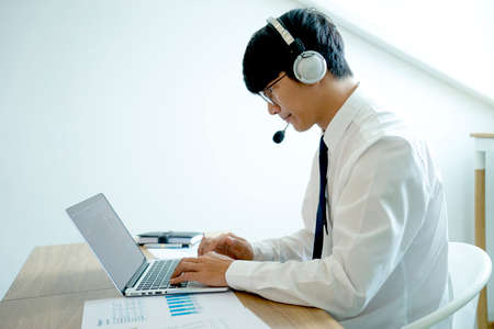 Business people are answering telephone conversations using a headset to provide details and answer customer questions call centre or telemarketing concept.の写真素材