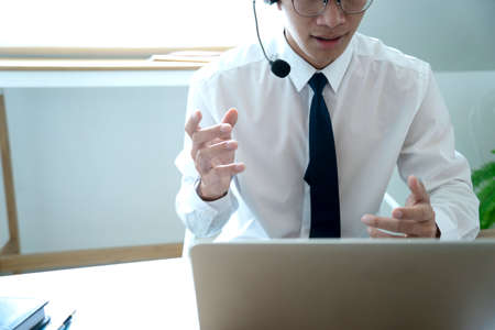 Business people are answering telephone conversations using a headset to provide details and answer customer questions call centre or telemarketing concept.の写真素材
