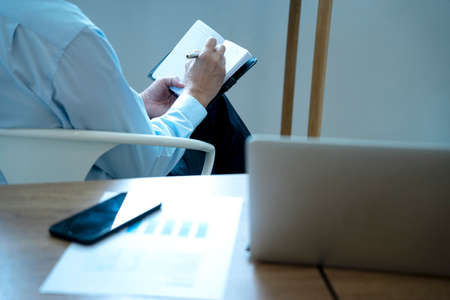 Smart businessman executive ceo or manager  sitting  thinking on a chair in the office  his hand hold the pen with more copy space.の写真素材