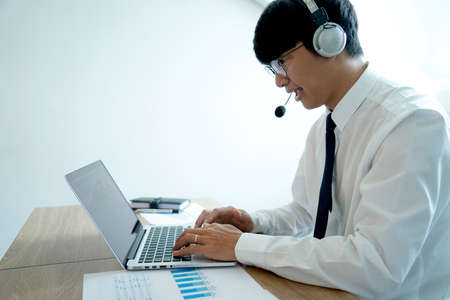 Business people are answering telephone conversations using a headset to provide details and answer customer questions call centre or telemarketing concept.の写真素材