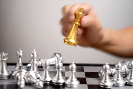 Businessman hand move one gold King chess to force to silver chess falling concept business win victory in trade war battlesの写真素材