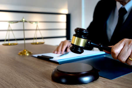 The judge's gavel handle is set to be hammered down as a sign of a judgment legal firm law concept.
