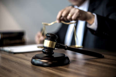 Focus on gavel and scales on the table background Lawyer or judge are discussion  consultation  and advice about law in law firm sepia vintage tone.の写真素材