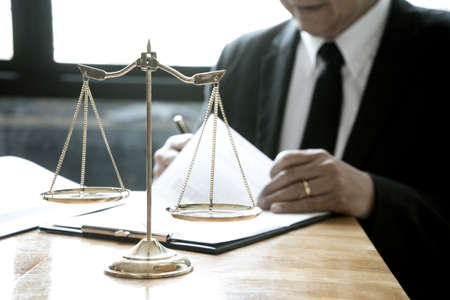 focusing on balance the attorneys or judge are reading legal books  in the law firm to prepare laws that will be used in legal proceedings.の写真素材