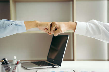 Two businesspeople fist bump dealing mission business with smile feel happy to working with success teamwork.の写真素材