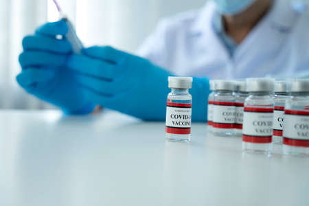 Scientists or doctor are preparing a covid-19 vaccine with syringe for the public to prevent infection bottle with the vaccine for coronavirus cure in the labÂ の写真素材