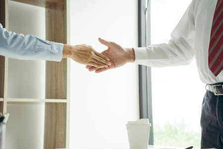 Two business people are shaking hands to congratulate them on a successful business deal.の写真素材