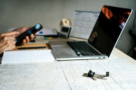 Focus on clip paper on  the white table of the  businessman use moble phone who working from home