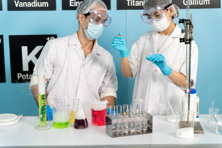 The lab team is looking at the chemicals and the mixing process happily in the chemistry lab.