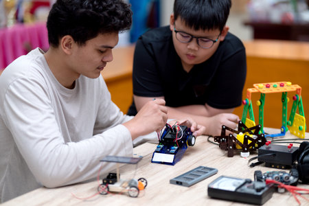 young man and a boy studying electronic assembly as an experiment for robotic invention on the table...