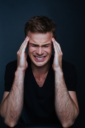 Handsome man feels painful headache