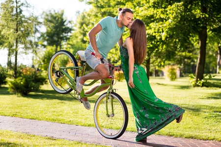 Wonderful kiss of couple on park background.の写真素材