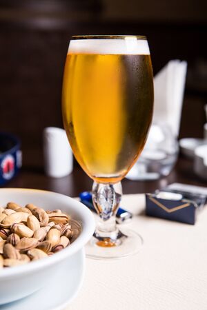Glass of beer and peanut on the wooden background.の写真素材