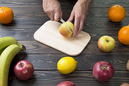 Woman cuts an apple with a knife.の写真素材
