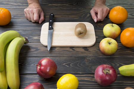 Woman is ready to cut fruit with a knife.の写真素材