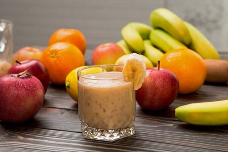 banana smoothie in a glass on wood.の写真素材
