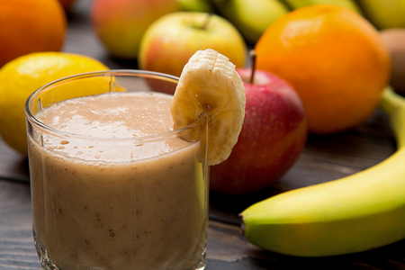 banana smoothie in a glass on wood.の写真素材