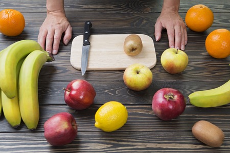 Woman is ready to cut fruit with a knife.の写真素材